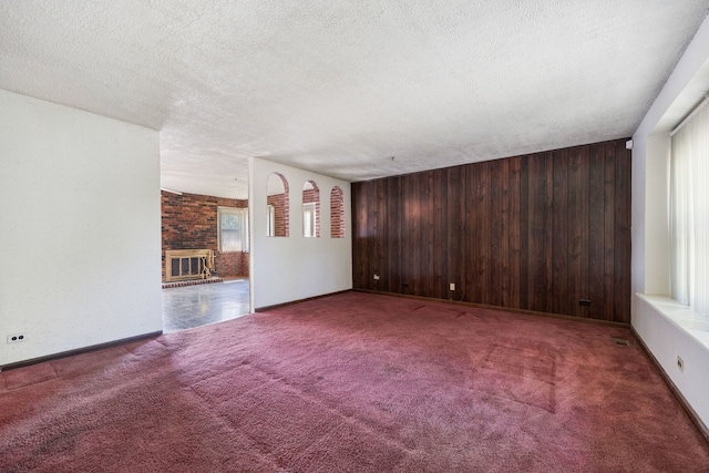 17433 Appletree Dr, Hazel Crest, IL 60429 - unfurnished living room with carpet floors, wooden walls, a fireplace, and a textured ceiling