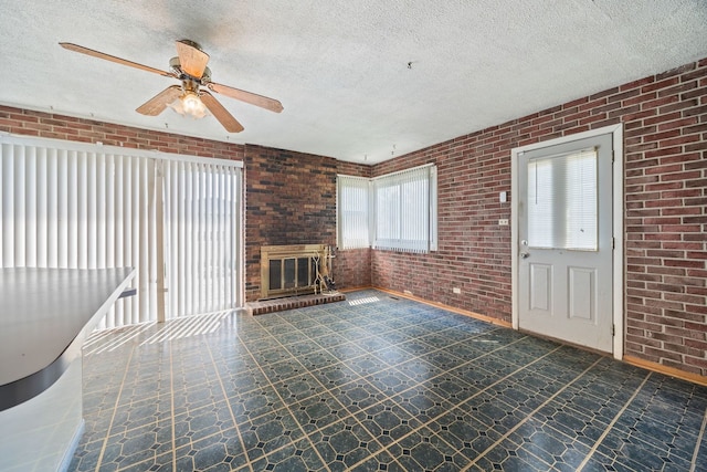 17433 Appletree Dr, Hazel Crest, IL 60429 - unfurnished living room with brick wall, healthy amount of natural light, a ceiling fan, and a textured ceiling