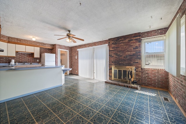 17433 Appletree Dr, Hazel Crest, IL 60429 - unfurnished living room with brick wall, a ceiling fan, a textured ceiling, and a fireplace