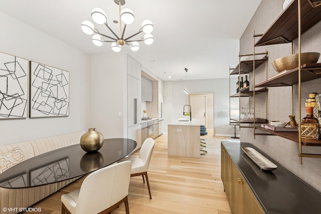 dining area featuring light wood finished floors and a notable chandelier