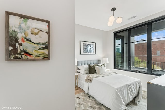 bedroom with visible vents, light wood finished floors, and baseboards
