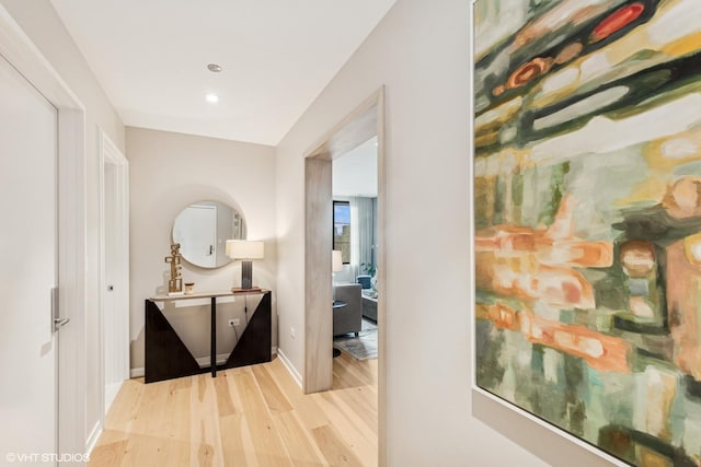 hall featuring baseboards, wood finished floors, and recessed lighting