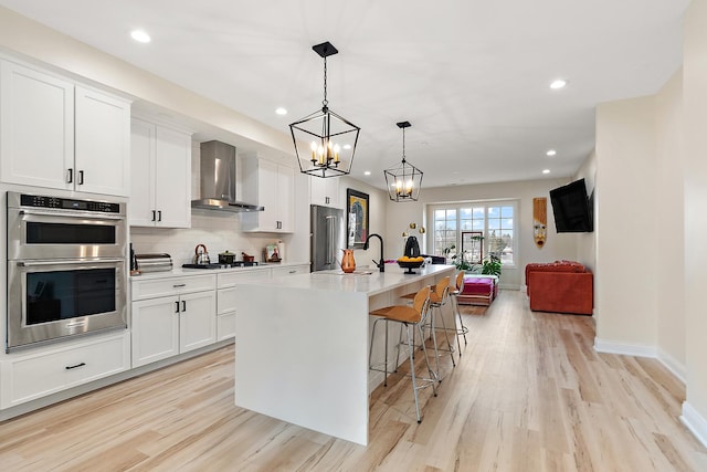 412 N Cass St Unit 4, Westmont, IL 60559 - kitchen featuring wall chimney range hood, light wood finished floors, stainless steel appliances, and a sink