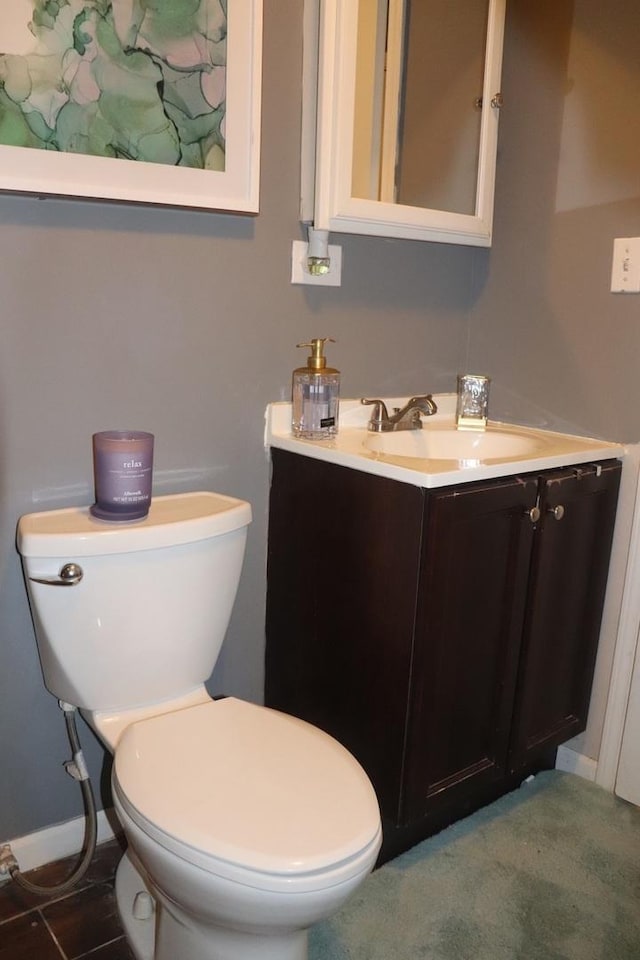 bathroom with vanity, toilet, and baseboards
