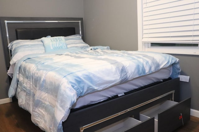 bedroom with baseboards and wood finished floors