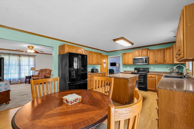 3504 Royal Oak Ct, Champaign, IL 61822 - kitchen with black appliances, crown molding, a kitchen island, ceiling fan, and light wood-style floors