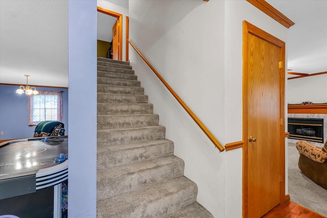 3504 Royal Oak Ct, Champaign, IL 61822 - stairway with wood finished floors, a premium fireplace, a chandelier, and ornamental molding