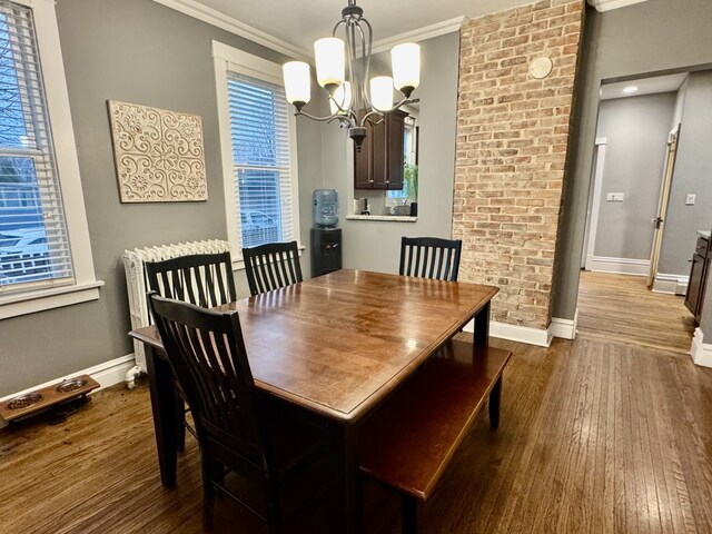 dining room with a notable chandelier, crown molding, baseboards, and dark wood-style flooring
