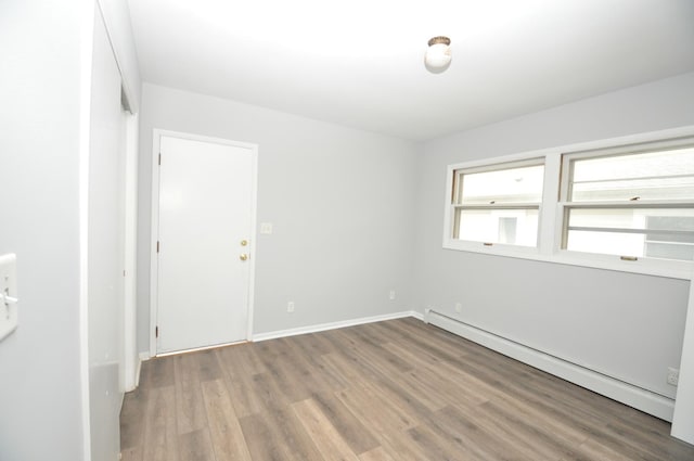 24109 64th Pl, Paddock Lake, WI 53168 - spare room featuring baseboard heating, wood finished floors, and baseboards