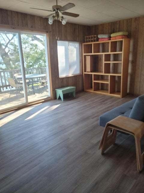 24109 64th Pl, Paddock Lake, WI 53168 - unfurnished room featuring wood walls, a ceiling fan, and wood finished floors