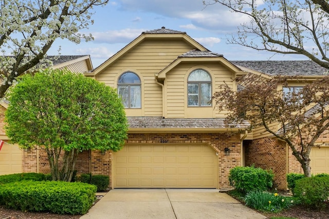 view of front of property featuring a garage, brick siding, and driveway
