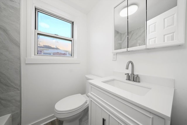 bathroom featuring baseboards, toilet, a shower, and vanity