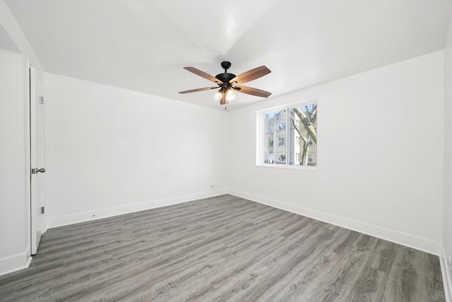 spare room with baseboards, ceiling fan, and wood finished floors