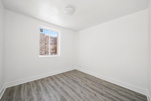 unfurnished room featuring baseboards and wood finished floors