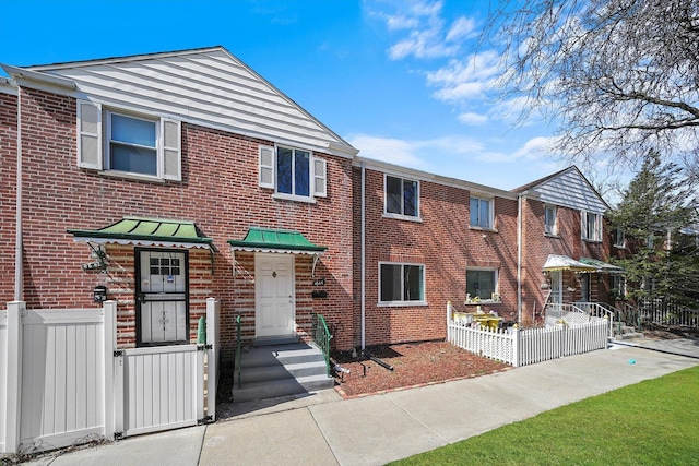 townhome / multi-family property featuring brick siding and fence
