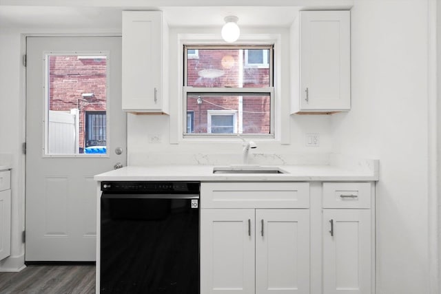 kitchen featuring white cabinetry, light countertops, a sink, dishwasher, and wood finished floors