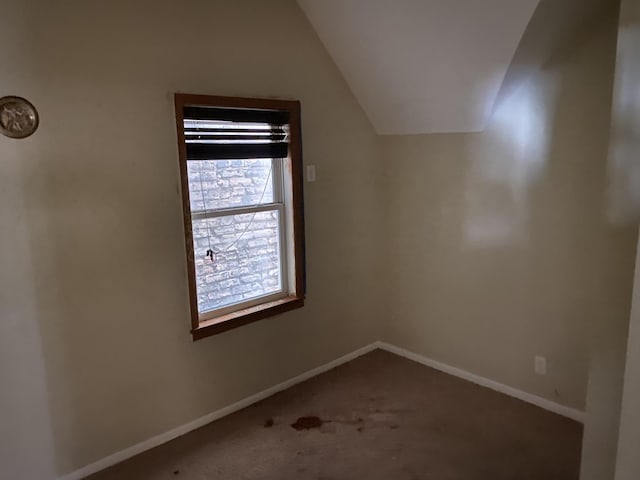 interior space featuring baseboards, carpet, and vaulted ceiling