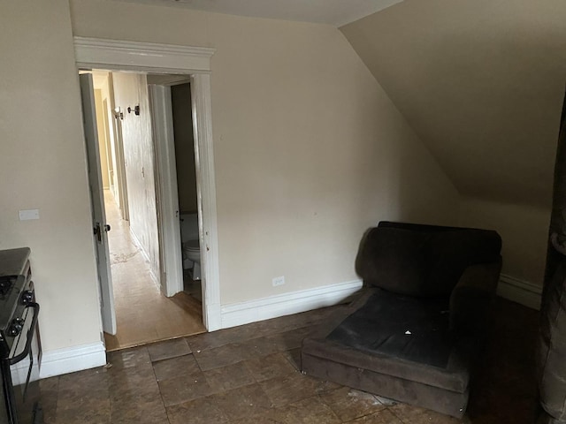 sitting room featuring vaulted ceiling and baseboards