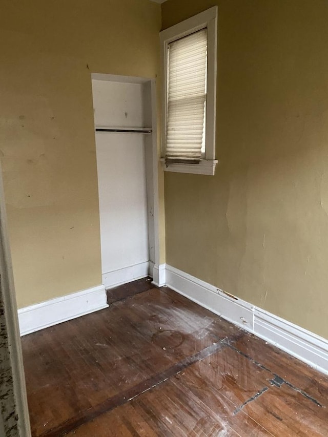 unfurnished bedroom featuring baseboards and hardwood / wood-style floors