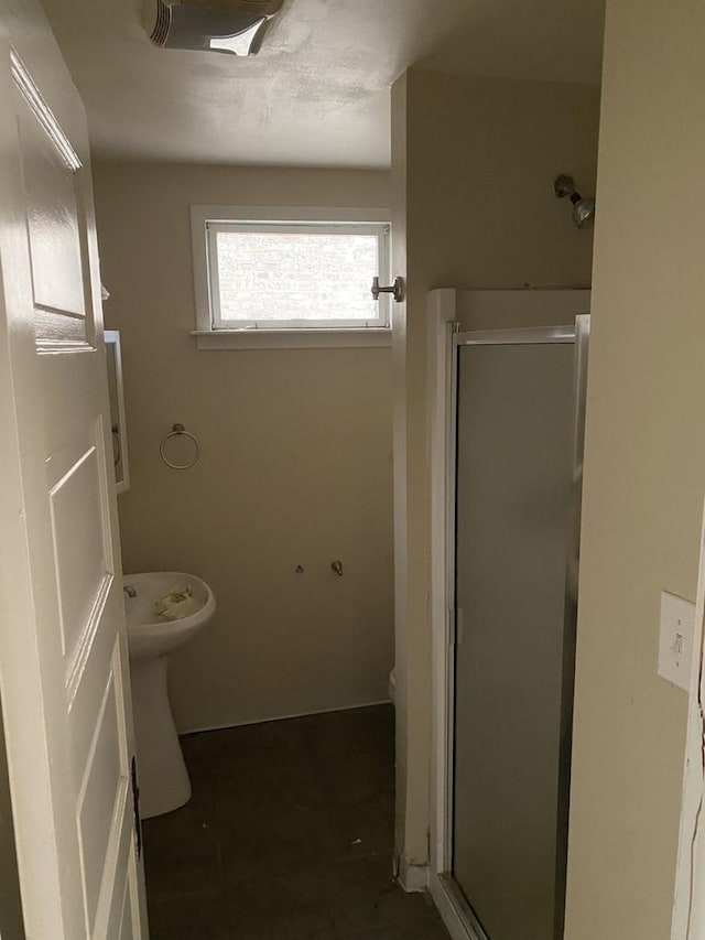 bathroom featuring toilet and a shower stall