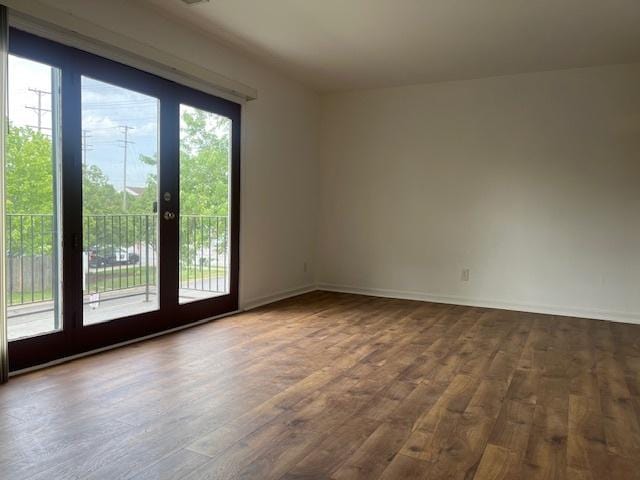 spare room featuring dark wood finished floors and baseboards