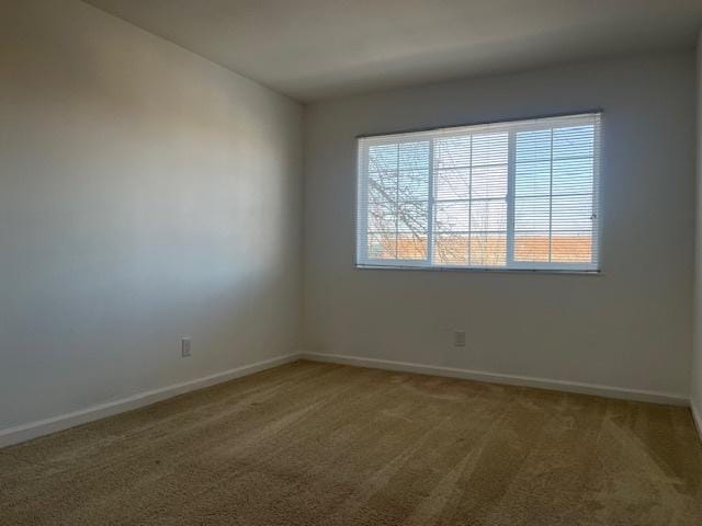 carpeted spare room with baseboards