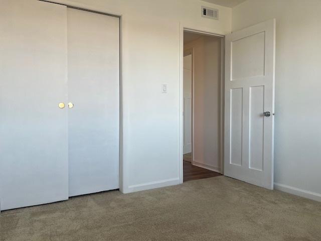 unfurnished bedroom featuring carpet floors, a closet, and baseboards