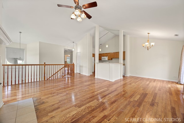 2319 Georgetown Ct, Aurora, IL 60503 - unfurnished living room with a ceiling fan, a chandelier, light wood-style floors, and high vaulted ceiling