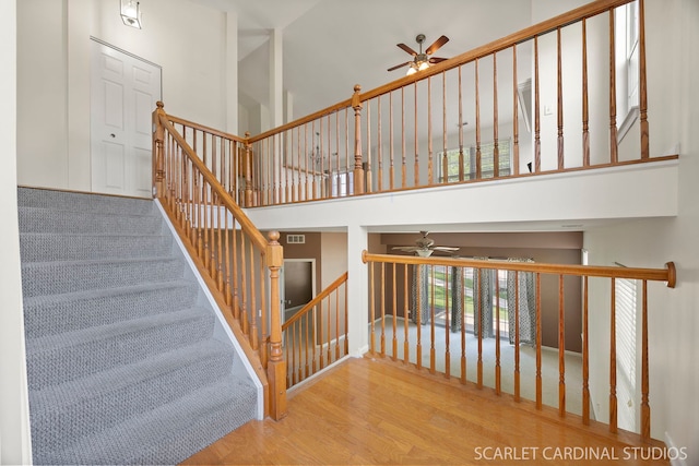 2319 Georgetown Ct, Aurora, IL 60503 - staircase featuring a ceiling fan, wood finished floors, and a high ceiling