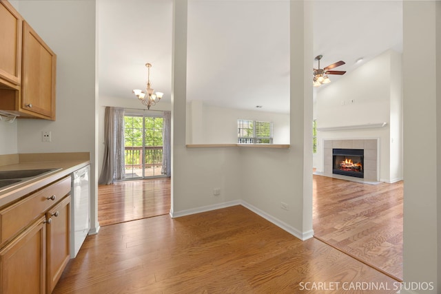 2319 Georgetown Ct, Aurora, IL 60503 - kitchen featuring light wood finished floors, a chandelier, a tiled fireplace, dishwasher, and a ceiling fan