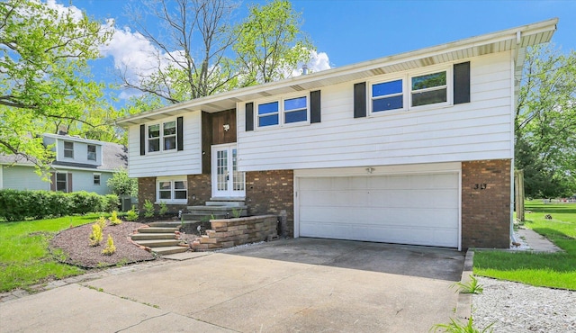 313 W Church St, Savoy, IL 61874 - split foyer home featuring a garage, driveway, french doors, and brick siding