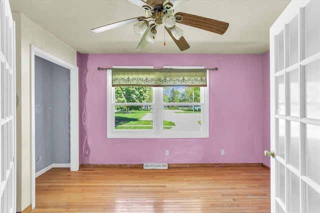 313 W Church St, Savoy, IL 61874 - unfurnished room featuring visible vents, a ceiling fan, light wood-style flooring, and a textured ceiling