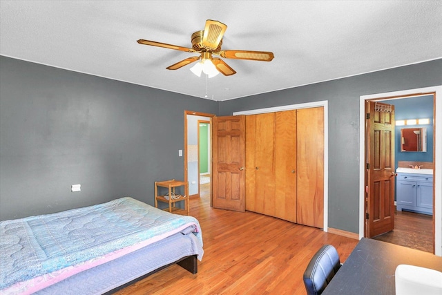 313 W Church St, Savoy, IL 61874 - bedroom with a closet, light wood-style floors, baseboards, connected bathroom, and a sink