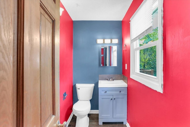 313 W Church St, Savoy, IL 61874 - half bathroom featuring vanity, baseboards, toilet, and wood finished floors