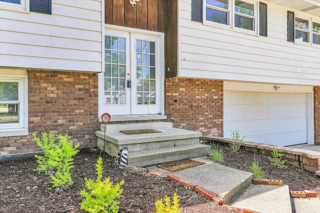 313 W Church St, Savoy, IL 61874 - doorway to property featuring brick siding, french doors, and a garage