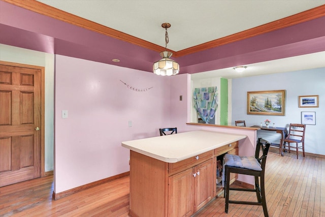 313 W Church St, Savoy, IL 61874 - kitchen featuring light countertops, baseboards, ornamental molding, and light wood-style flooring