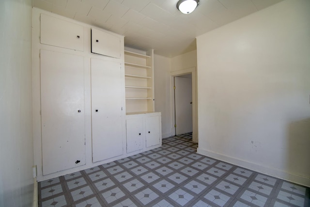 unfurnished bedroom featuring a closet, light floors, and baseboards