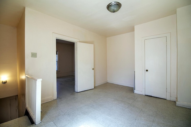 unfurnished bedroom featuring light floors and baseboards