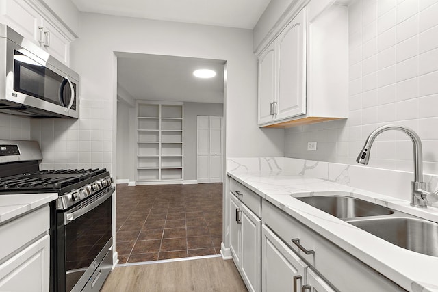 254 E Bailey Rd Unit M, Naperville, IL 60565 - kitchen featuring light stone countertops, a sink, stainless steel appliances, backsplash, and white cabinets