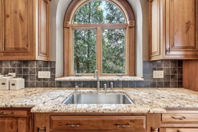 831 Alberosky Way, Batavia, IL 60510 - kitchen with a sink, brown cabinets, light stone countertops, and decorative backsplash