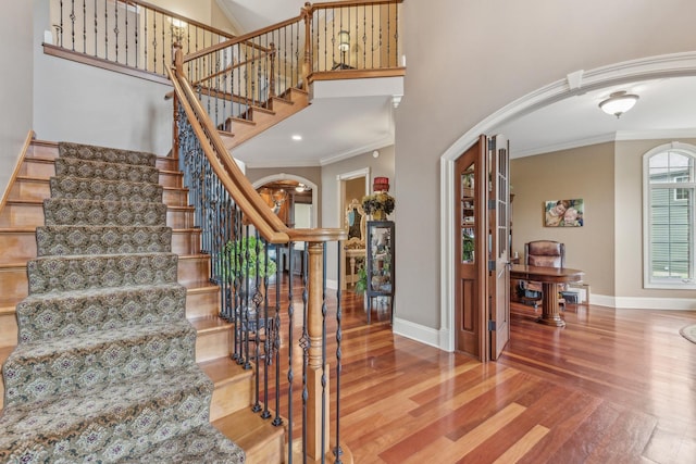 831 Alberosky Way, Batavia, IL 60510 - staircase with ornamental molding, baseboards, wood finished floors, arched walkways, and a high ceiling