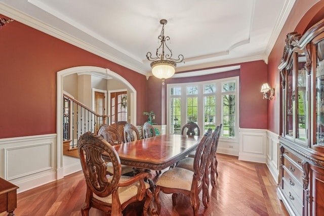 831 Alberosky Way, Batavia, IL 60510 - dining area featuring a wainscoted wall, light wood-style flooring, arched walkways, a tray ceiling, and crown molding