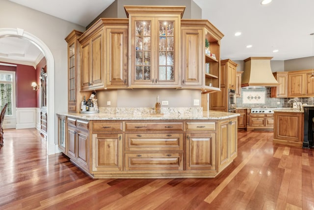 831 Alberosky Way, Batavia, IL 60510 - kitchen featuring premium range hood, light wood finished floors, appliances with stainless steel finishes, wainscoting, and arched walkways