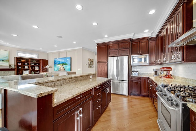 934 Robertson Rd, South Elgin, IL 60177 - kitchen featuring appliances with stainless steel finishes, ornamental molding, wall chimney range hood, reddish brown cabinets, and recessed lighting