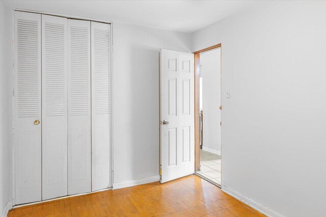5817 W 16th St, Cicero, IL 60804 - unfurnished bedroom featuring baseboards, a closet, and light wood finished floors
