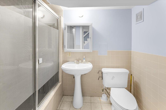 5817 W 16th St, Cicero, IL 60804 - bathroom with tile patterned flooring, tile walls, toilet, a stall shower, and visible vents