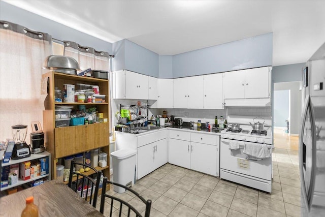 5817 W 16th St, Cicero, IL 60804 - kitchen with white cabinets, white gas stove, and tasteful backsplash