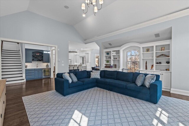 living area featuring dark wood finished floors, beverage cooler, a bar, and lofted ceiling