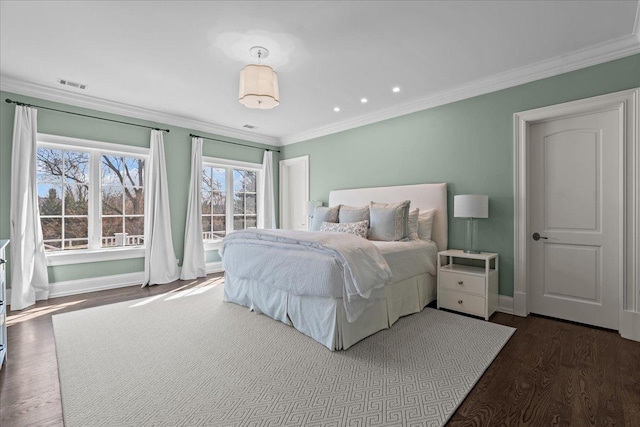 bedroom with baseboards, visible vents, wood finished floors, and ornamental molding