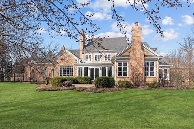 rear view of house featuring a chimney and a yard